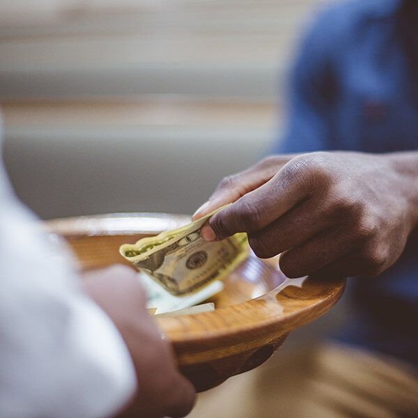 A closeup shot of a male donating money for church with a blurred background